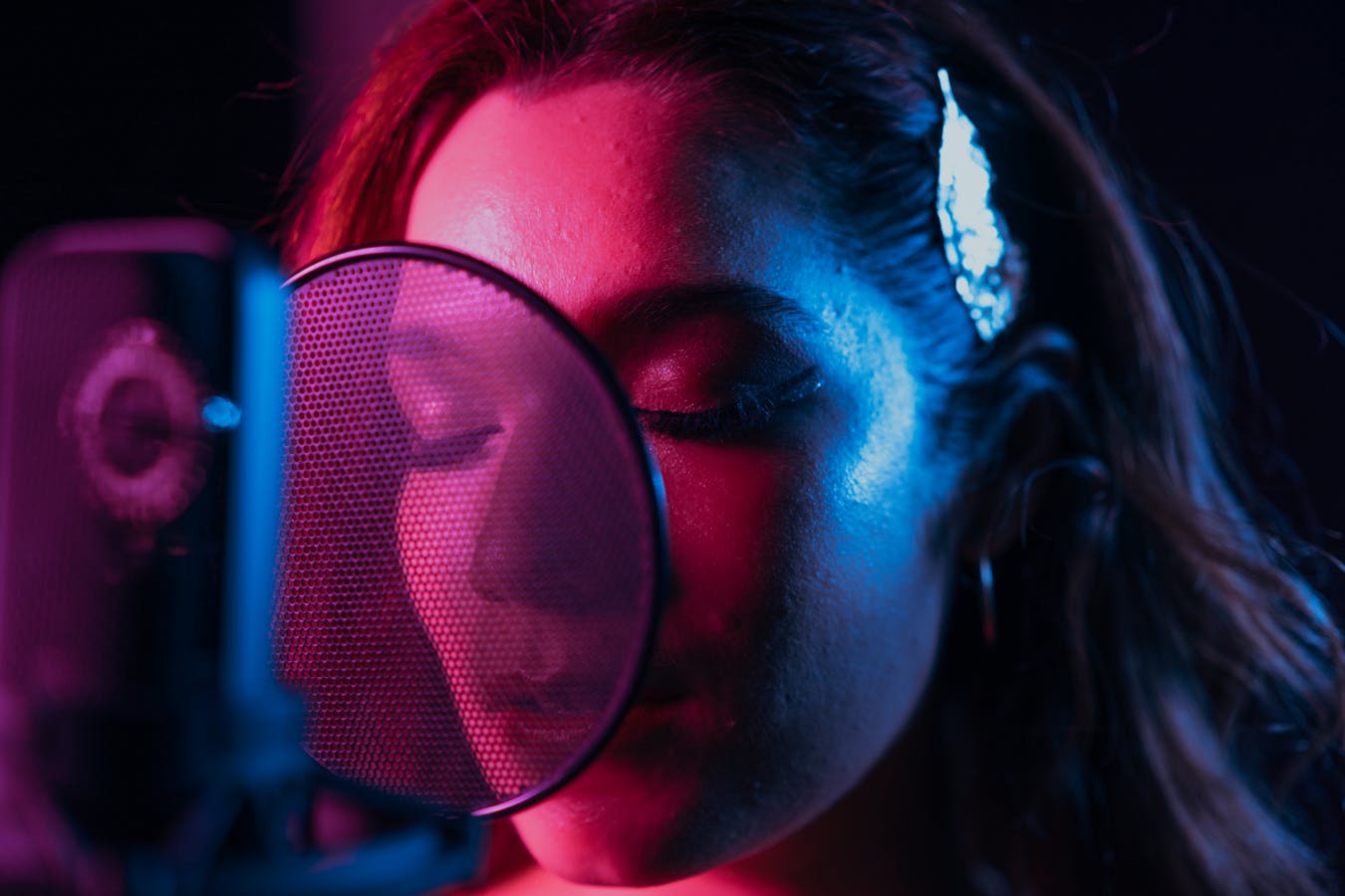 Podcast host recording in a studio with microphone and laptop