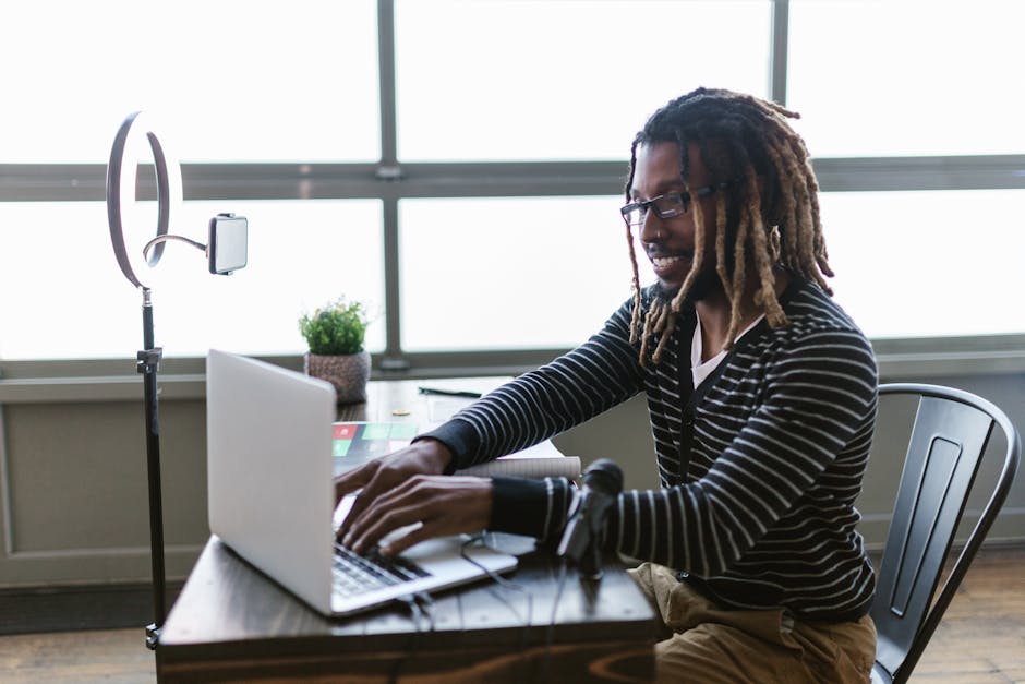 Podcast host planning episode CTA language on a laptop beside a studio microphone